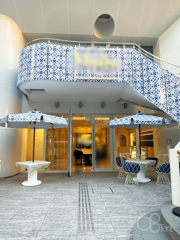 パラソルが店舗の外装デザインと一体となり、洗練されたテラス空間を作り出している様子